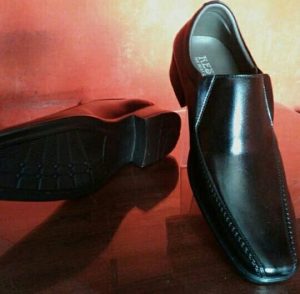 Sepatu kulit hitam yang dirawat dengan baik menggunakan cream semir kulit